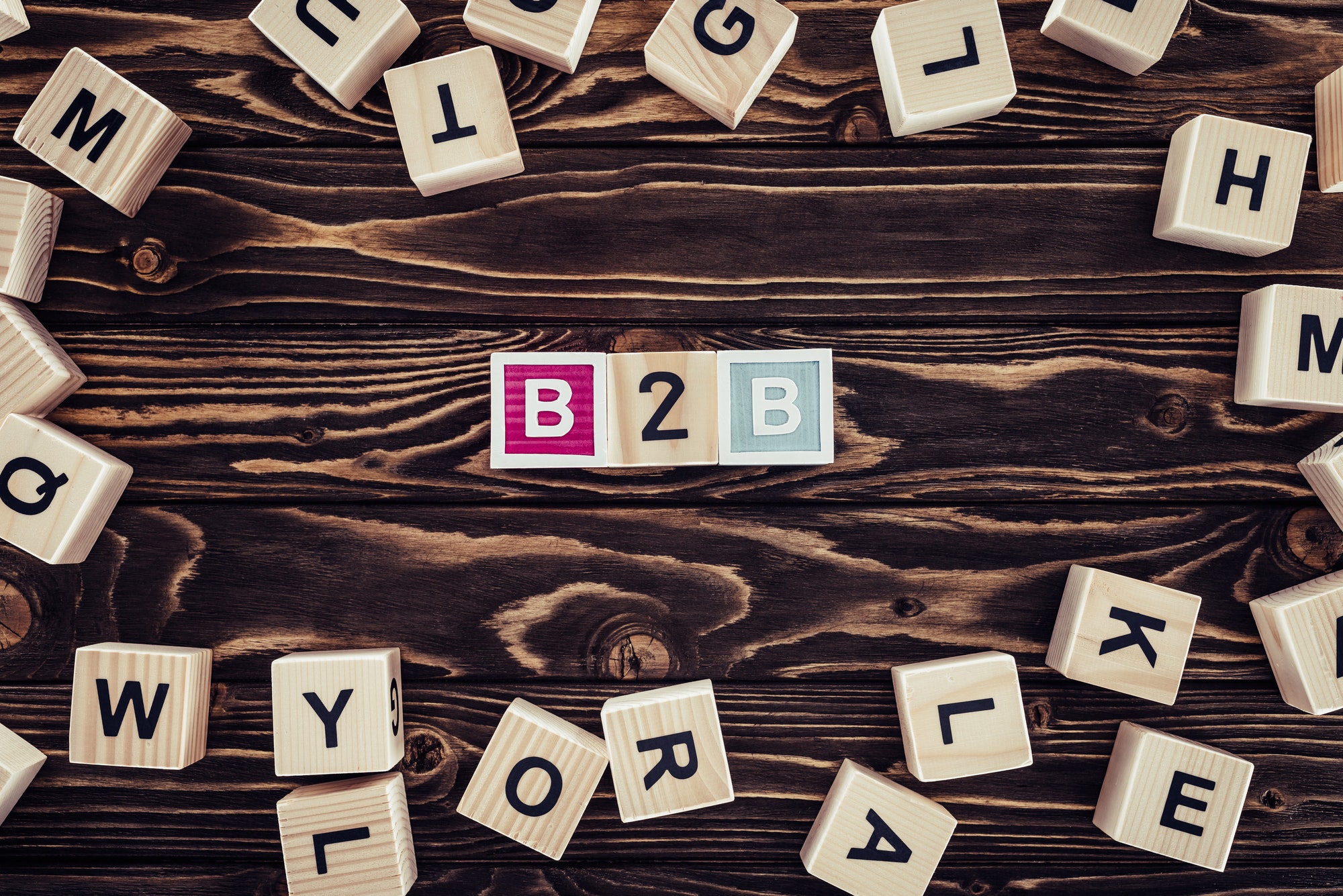 flat lay with b2b inscription made of blocks on brown wooden tabletop