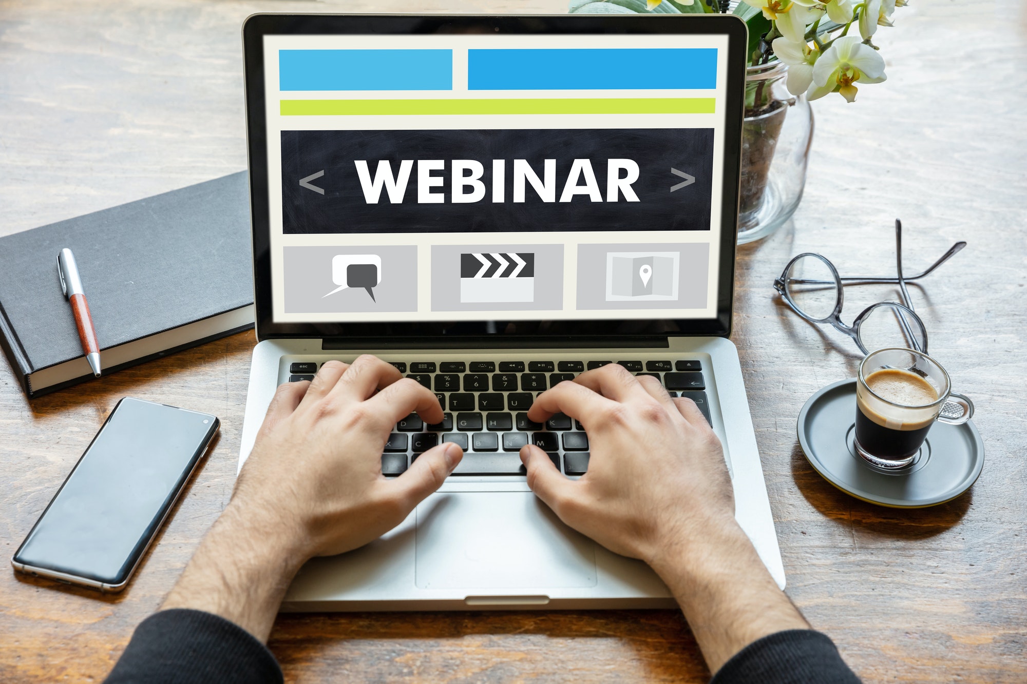 Man working on a laptop with the word webinar on the computer screen